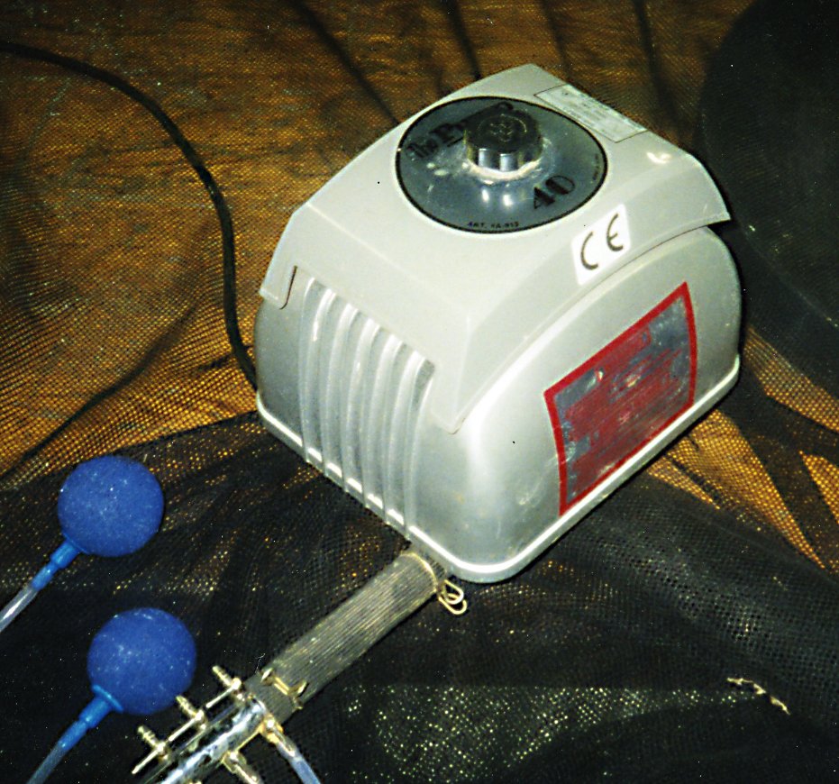 Silver water pump device with a control dial and attached hoses for water movement.